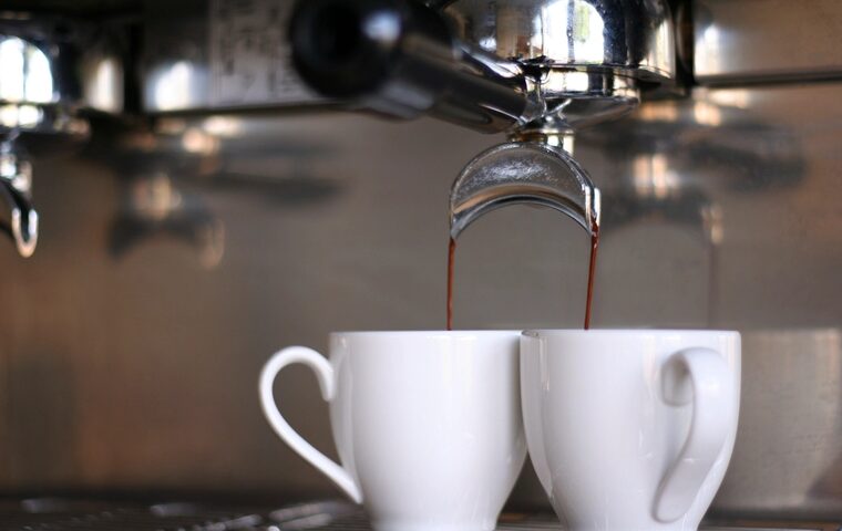 Espresso being poured from a coffee machine into two cups
